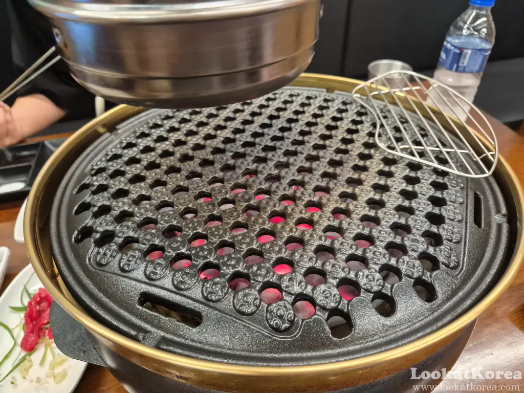 Perforated cast iron grill over hot charcoal at a Hanwoo restaurant